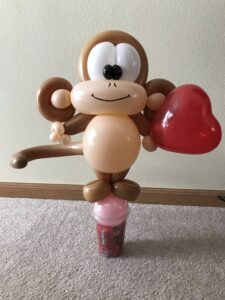 Balloon monkey holding a heart.