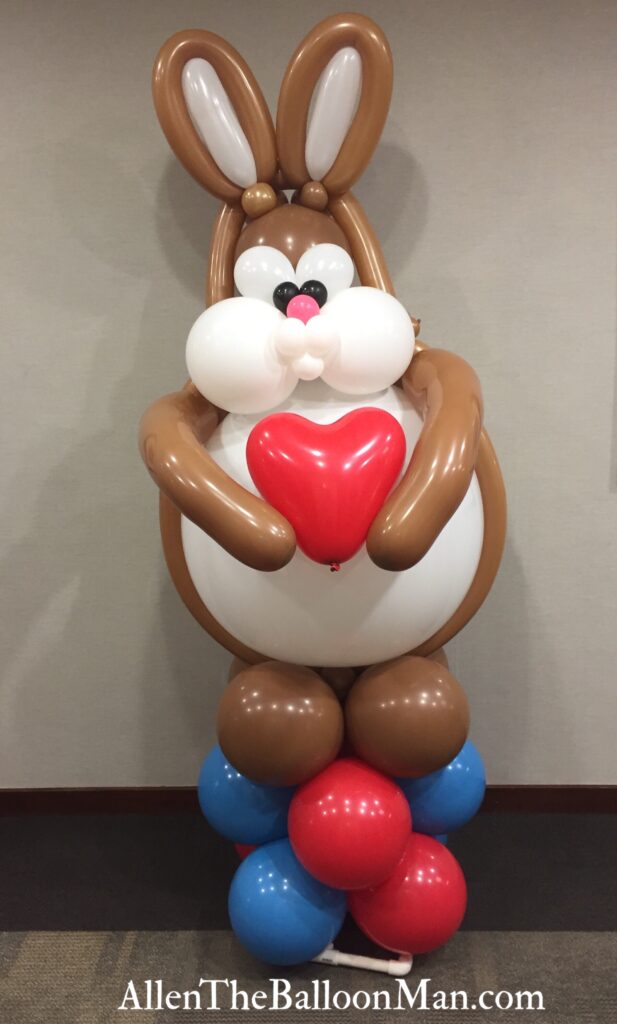 Tall balloon bunny holding a heart.