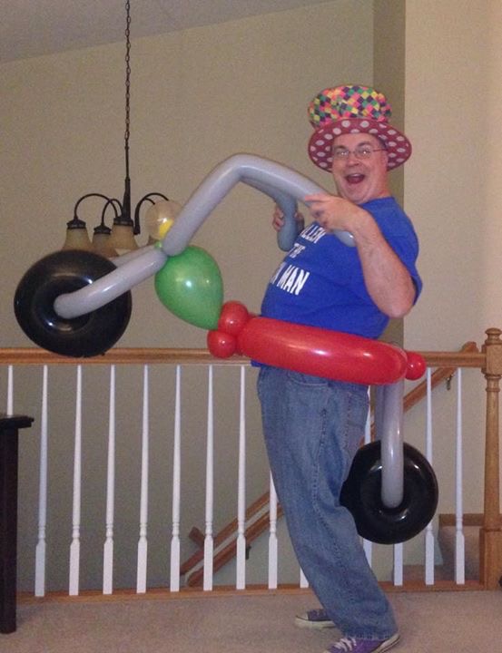 Allen The Balloon Man riding a balloon motorcylce.